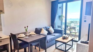 Un soggiorno moderno con tavolo da pranzo, divano e vista sulla città.