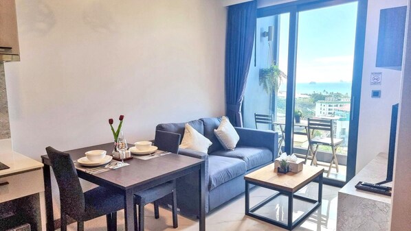 Ein modernes Wohnzimmer mit Esstisch, Sofa und Blick auf die Stadt.