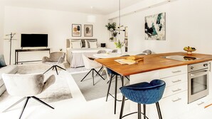 A modern living space with a dining area, kitchen, and a TV.