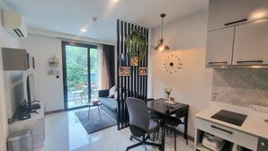 A modern kitchen with a dining area, a large window, and a view of the outdoors. - B506 - 1 Bedroom Serviced Apartment Top Floor Pool View at Ao Nang Beach (Tambon Ao Nang)