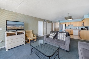A compact living space with a television, sofa, and coffee table. - Carousel 1712 by Seaside Vacations & Sales (Ocean City)
