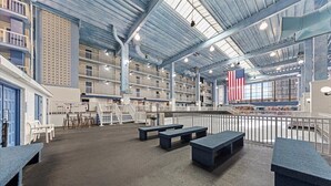 A spacious indoor area with high ceilings, multiple levels, and a large American flag.