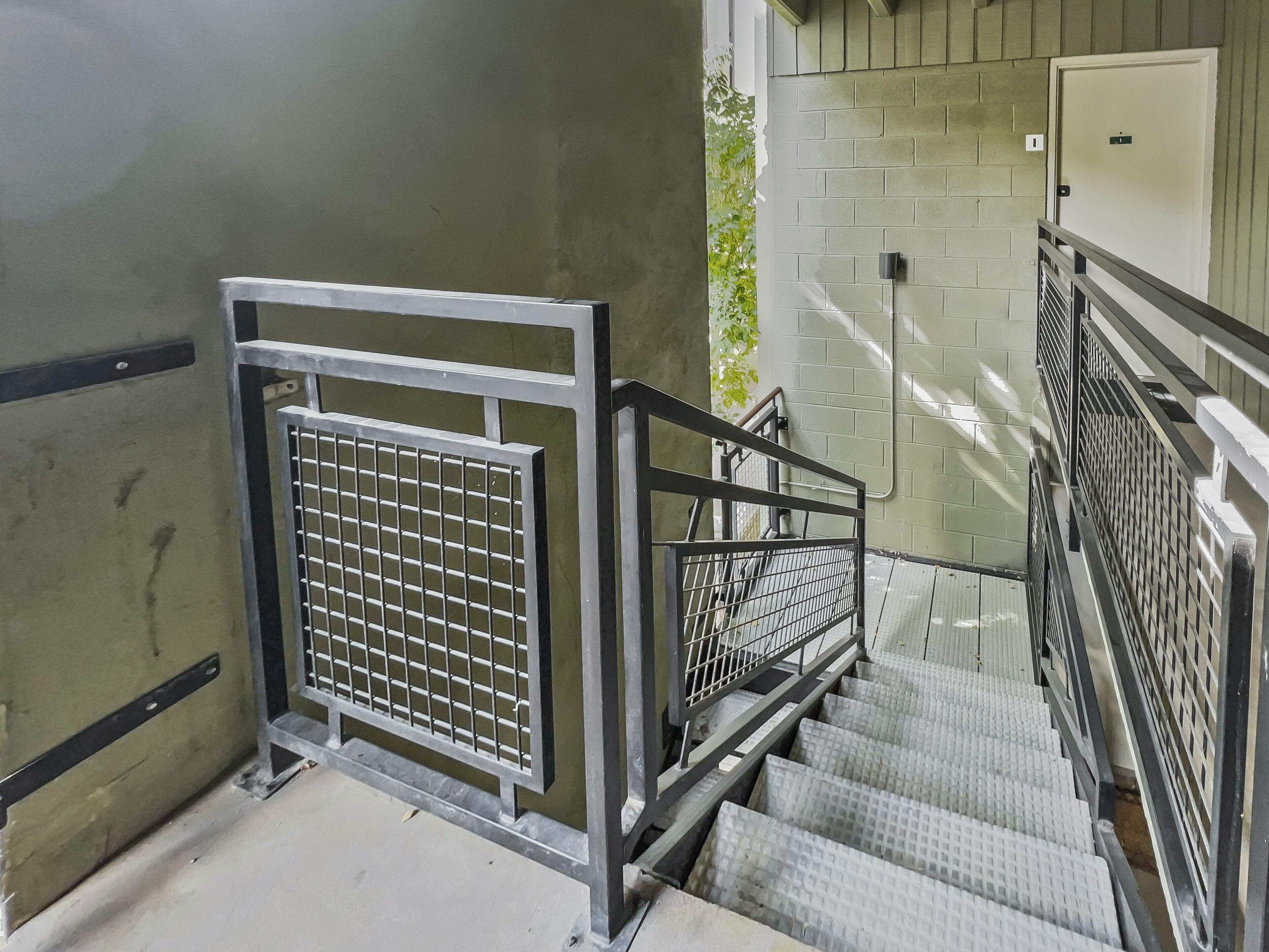 A staircase with metal railings and a security gate.