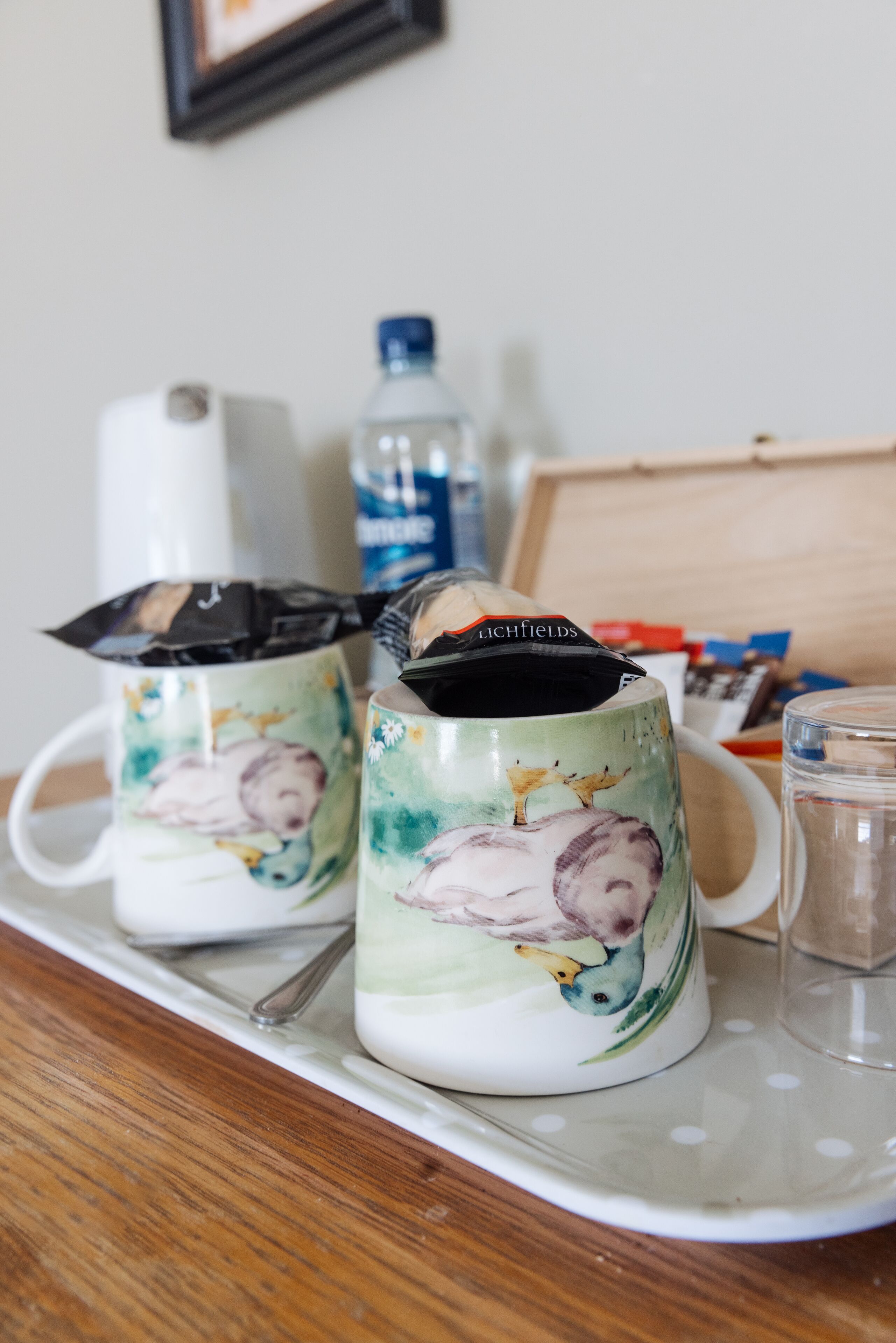 Twee keramische mokken met bloemendessins op een dienblad.