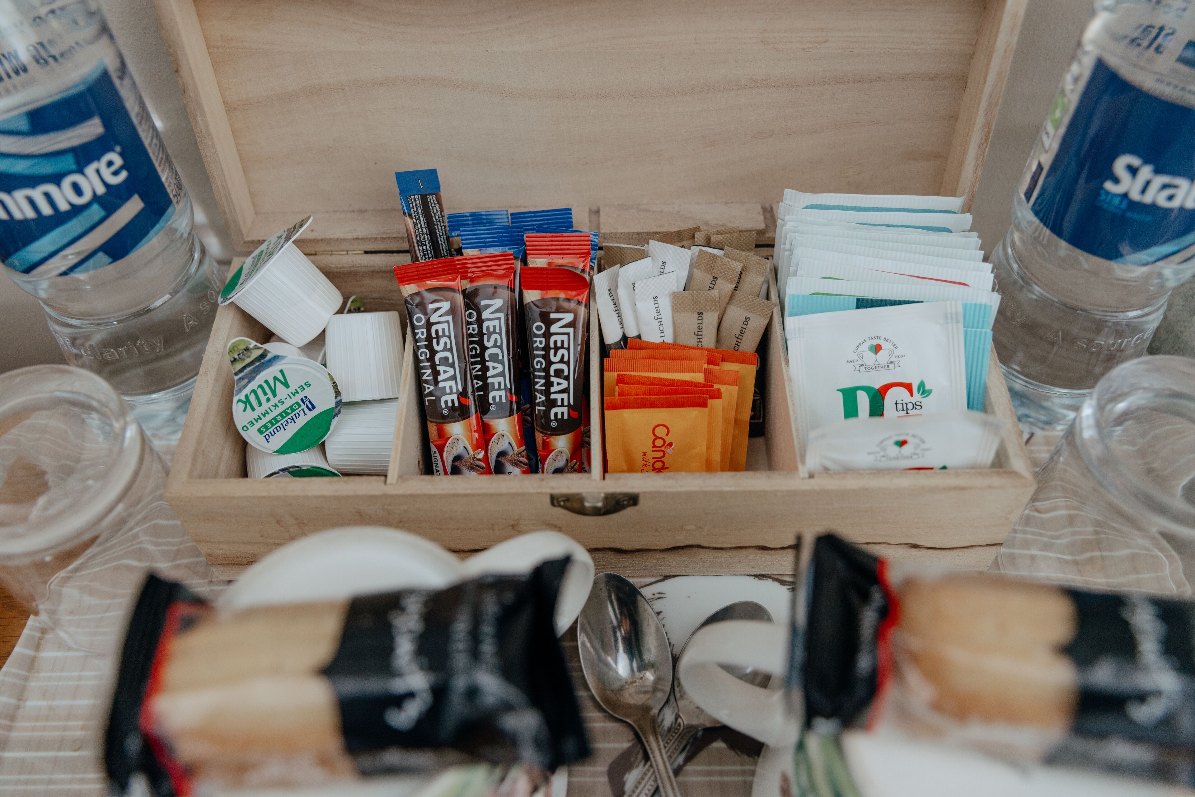 Puisessa laatikossa oli erilaisia tuotteita, kuten Nescafe-kahvipaketteja, pakkaus Mint-pastilleja ja joitain muita pieniä paketteja.