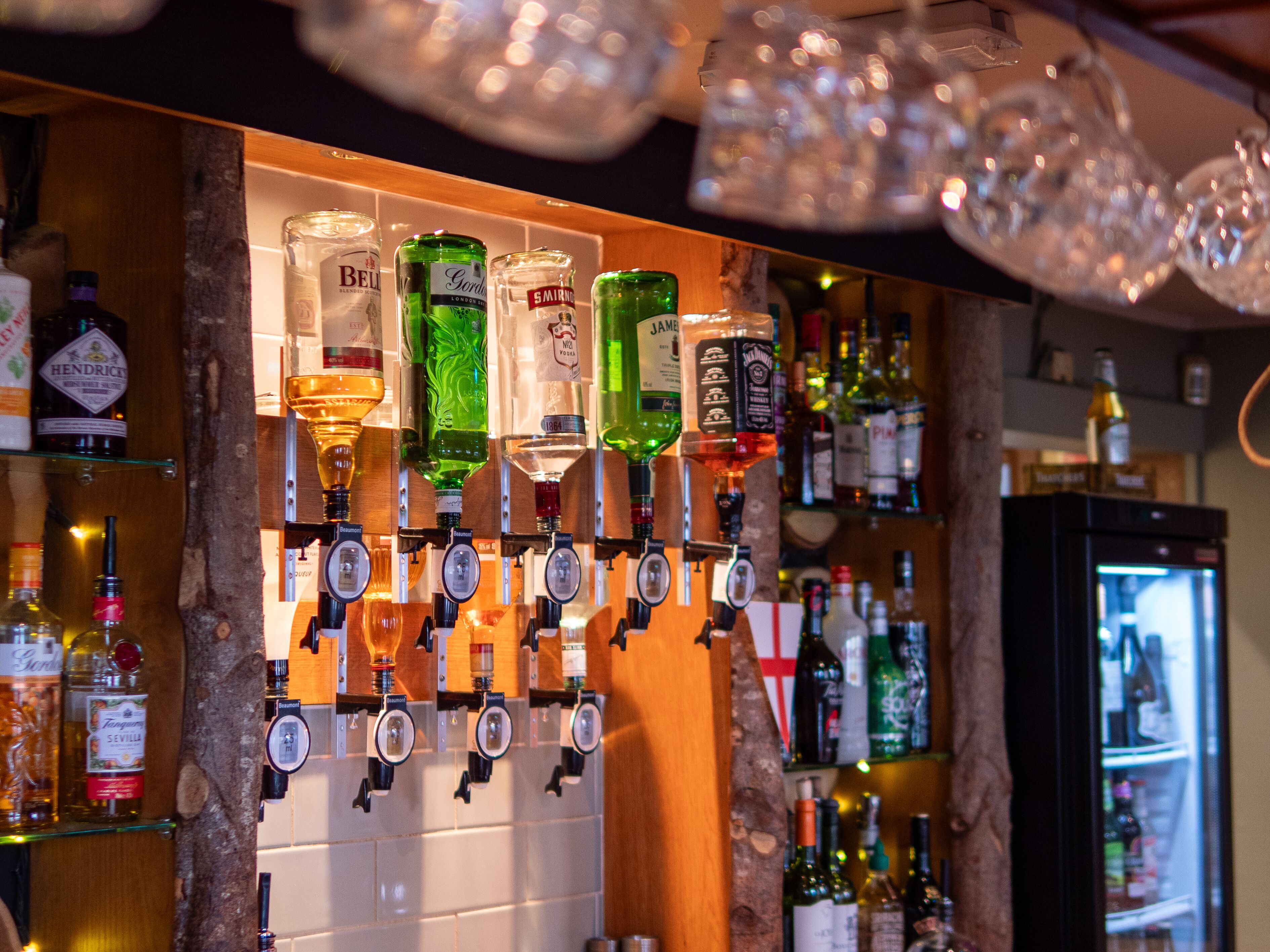 Una zona de bar con varios dispensadores de licores y botellas.