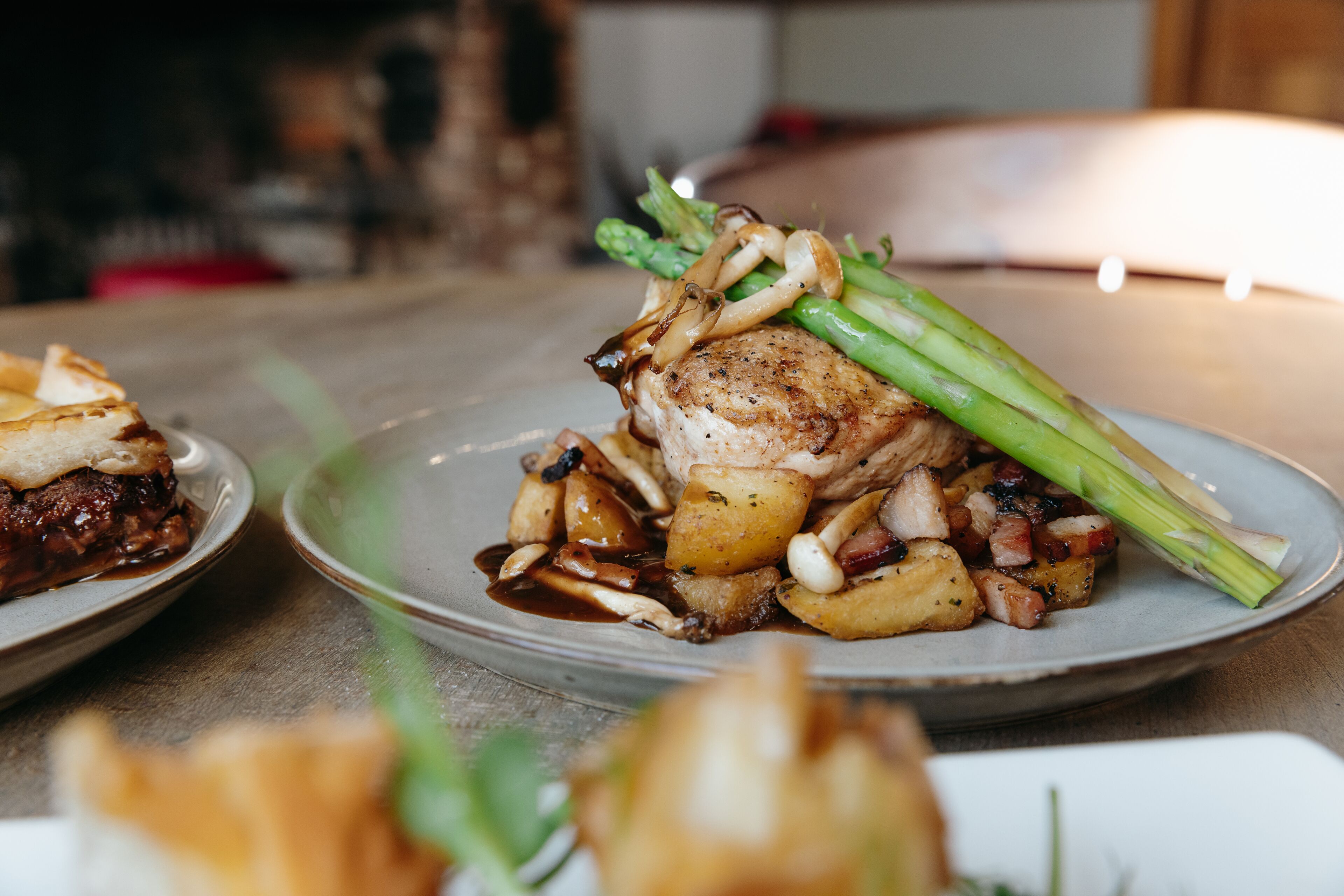 Een bord eten met vlees, aardappelen en asperges.