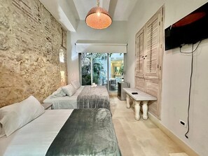 Un dormitorio con dos camas, una mesa de comedor y un televisor.