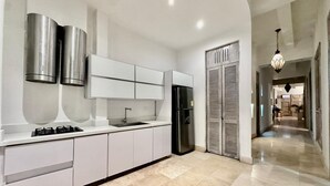 A modern kitchen with white cabinetry, a stainless steel refrigerator, and a gas stove.