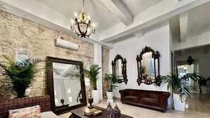 A spacious living room with a large mirror, a brown sofa, and a coffee table with decorative items.