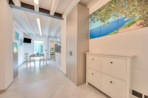 Un interior moderno con un comedor, un armario blanco y un cuadro de paisaje.