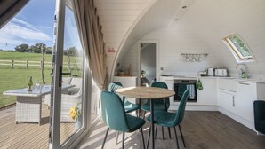 Een gezellige, moderne keuken met een eethoek, grote ramen en uitzicht op de omgeving.