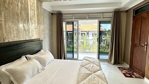 A modern bedroom with a large bed, a view to the outside, and a ceiling with a unique design. - Kisa apartments (Jinja)