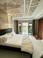 Un dormitorio moderno con una cama grande, vistas al exterior y un techo con un diseño único.