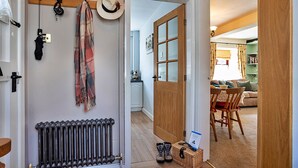Un couloir avec un radiateur, un chapeau et une écharpe à carreaux accrochés au mur.