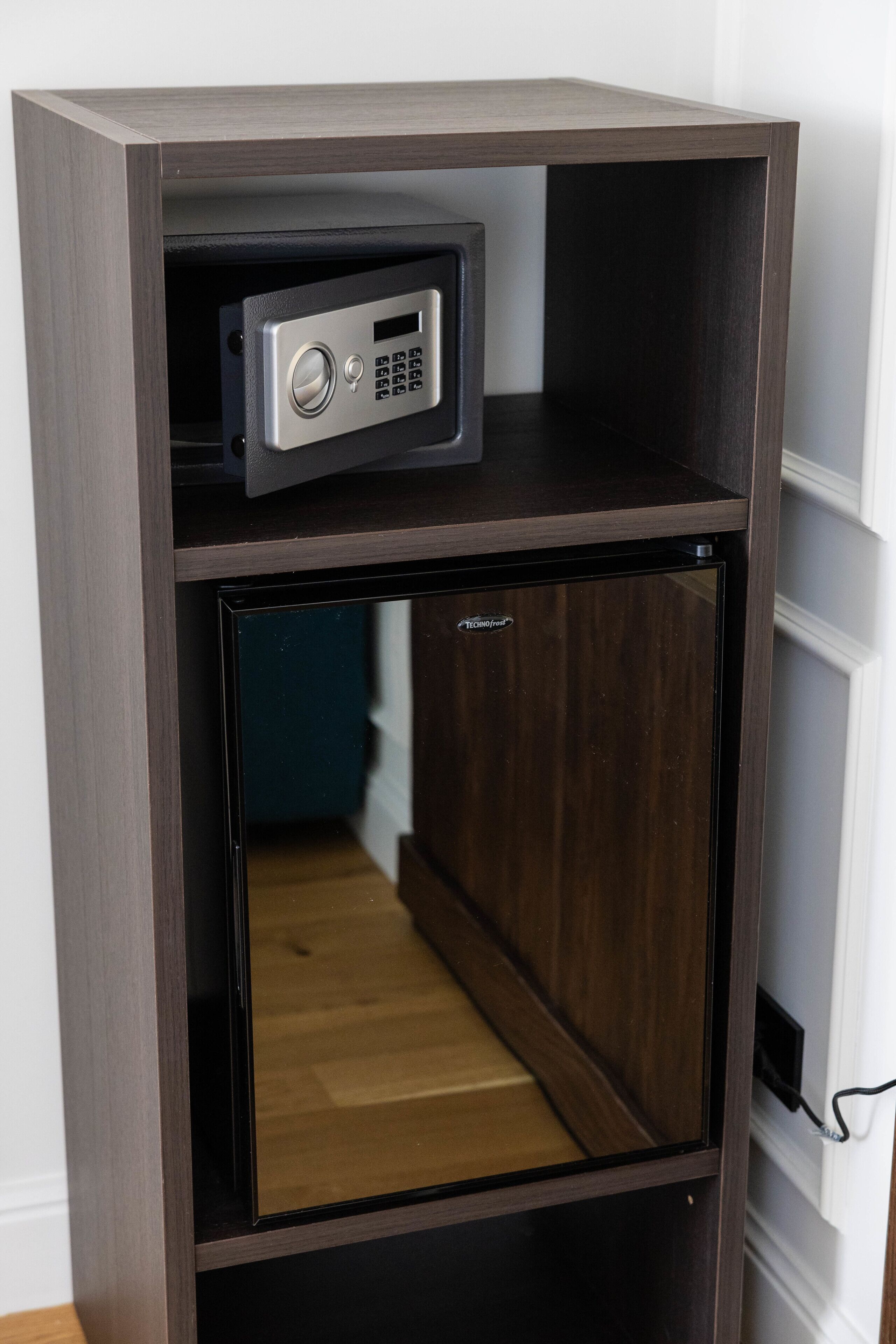 A dark wooden cabinet with a small built-in refrigerator and a lockable compartment.