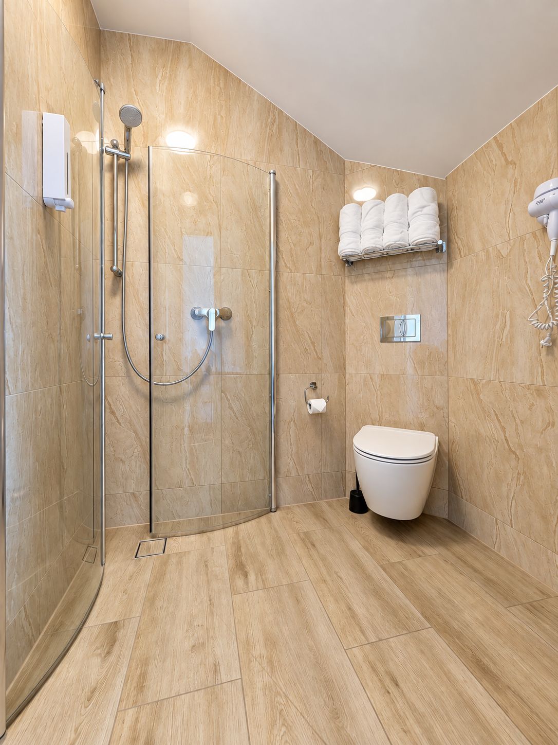 Une salle de bain moderne avec une douche à parois de verre, des toilettes et un porte-serviettes.