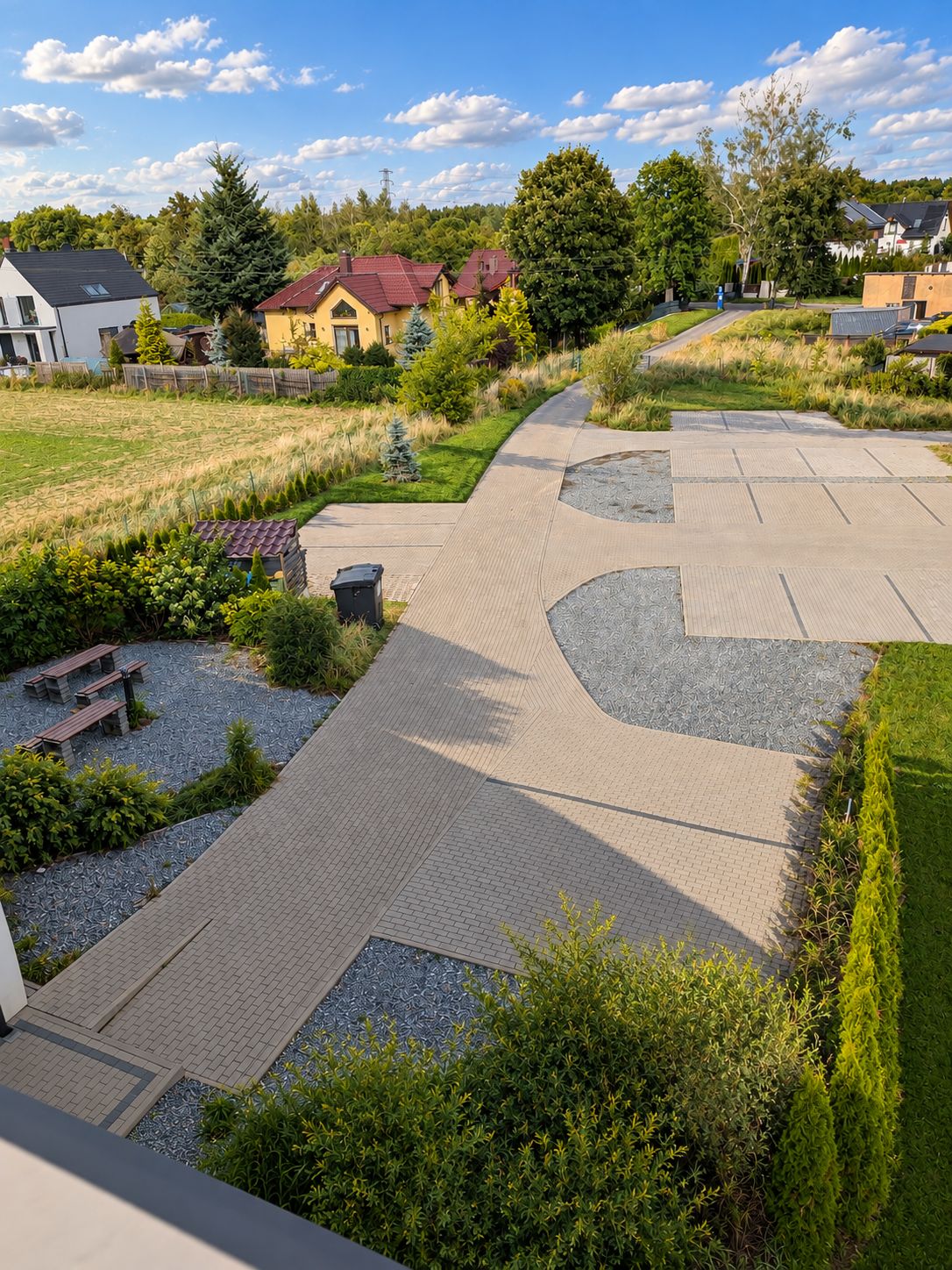 Un quartier résidentiel doté d’un chemin piétonnier dallé, de bancs et d’espaces verts.