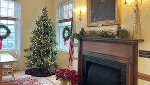 A room with a fireplace, a Christmas tree, and a portrait on the wall. - Crow's Nest Newport (Newport)