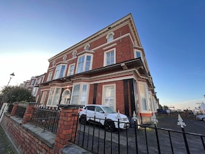 A two-story brick building with a white car parked in front. - Lakeview Court, Sea+Lake view, free parking (Southport)