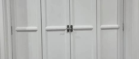 A white wardrobe with two doors and a small window above.