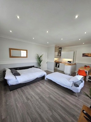 A room with two beds, a small kitchenette, and a dining area. - Lakeview Court, Sea+Lake view, free parking (Southport)