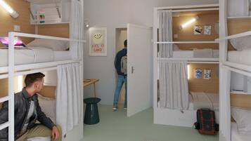 Un dormitorio con literas, una mesita pequeña y un cartel en la pared que dice 'Life is Good'.