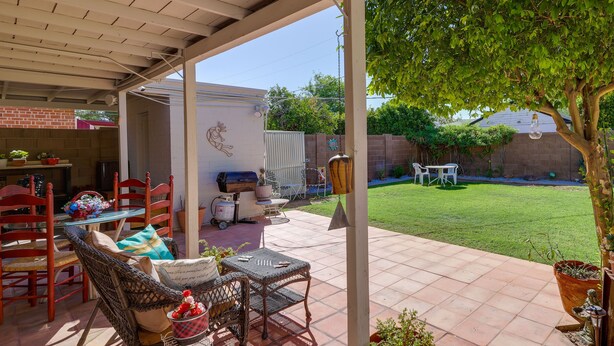 A covered patio with wicker furniture, a barbecue grill, and potted plants. - Phoenix Home w/ Patio: Near Downtown & Light Rail! (Phoenix)