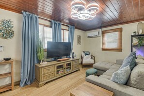 A living room with a flat-screen TV, wooden ceiling, and a sofa with patterned cushions. - 2 Blocks to Sand! Breezy Atlantic Beach Escape (Myrtle Beach)