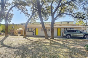 A building with a yellow door, a parked SUV, and two trees in the foreground. - 2 Blocks to Sand! Breezy Atlantic Beach Escape (Myrtle Beach)