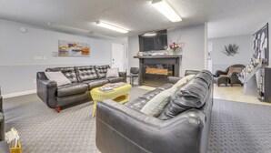 Un salon moderne avec deux canapés en cuir, un téléviseur à écran plat et une cheminée.