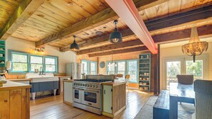 A spacious kitchen with wooden cabinets, a large stove, and pendant lighting. - Luxe 14-acre Vermont Countryside Lodge! (Washington)
