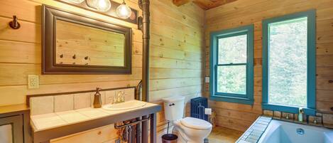 A wooden cabin bathroom with a sink, toilet, and bathtub.