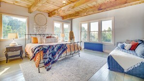 A bedroom with a bed, bedside tables, a dresser, and a large window. - Luxe 14-acre Vermont Countryside Lodge! (Washington)