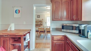 A kitchen with wooden cabinets, a stainless steel microwave, and a coffee maker. - Royal Oak Home: 13 Mi to Downtown Detroit (Royal Oak)