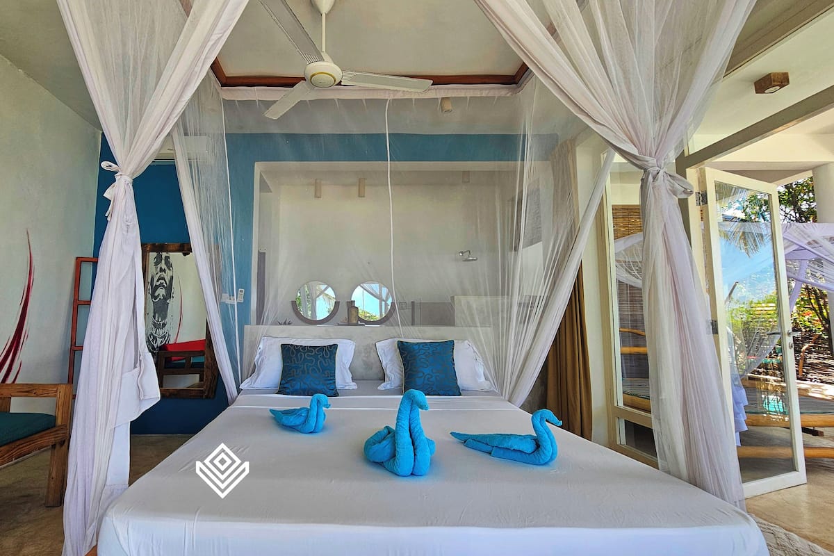 Un dormitorio con cama con dosel, un espejo grande y una pared con un diseño gráfico.