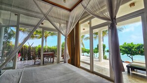 Una stanza con un letto, ampie finestre e vista sull'oceano.