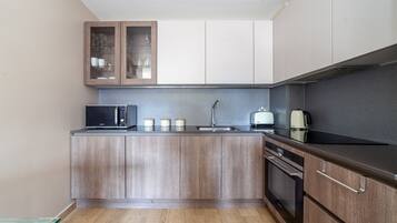 Apartamento | Cocina privada | Frigorífico, microondas, horno y placa de cocina