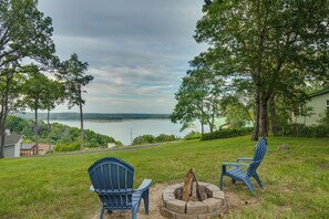 A lakeside view with two blue Adirondack chairs and a fire pit. - Norfork Lake-view Retreat w/ Covered Boat Parking (Mountain Home)
