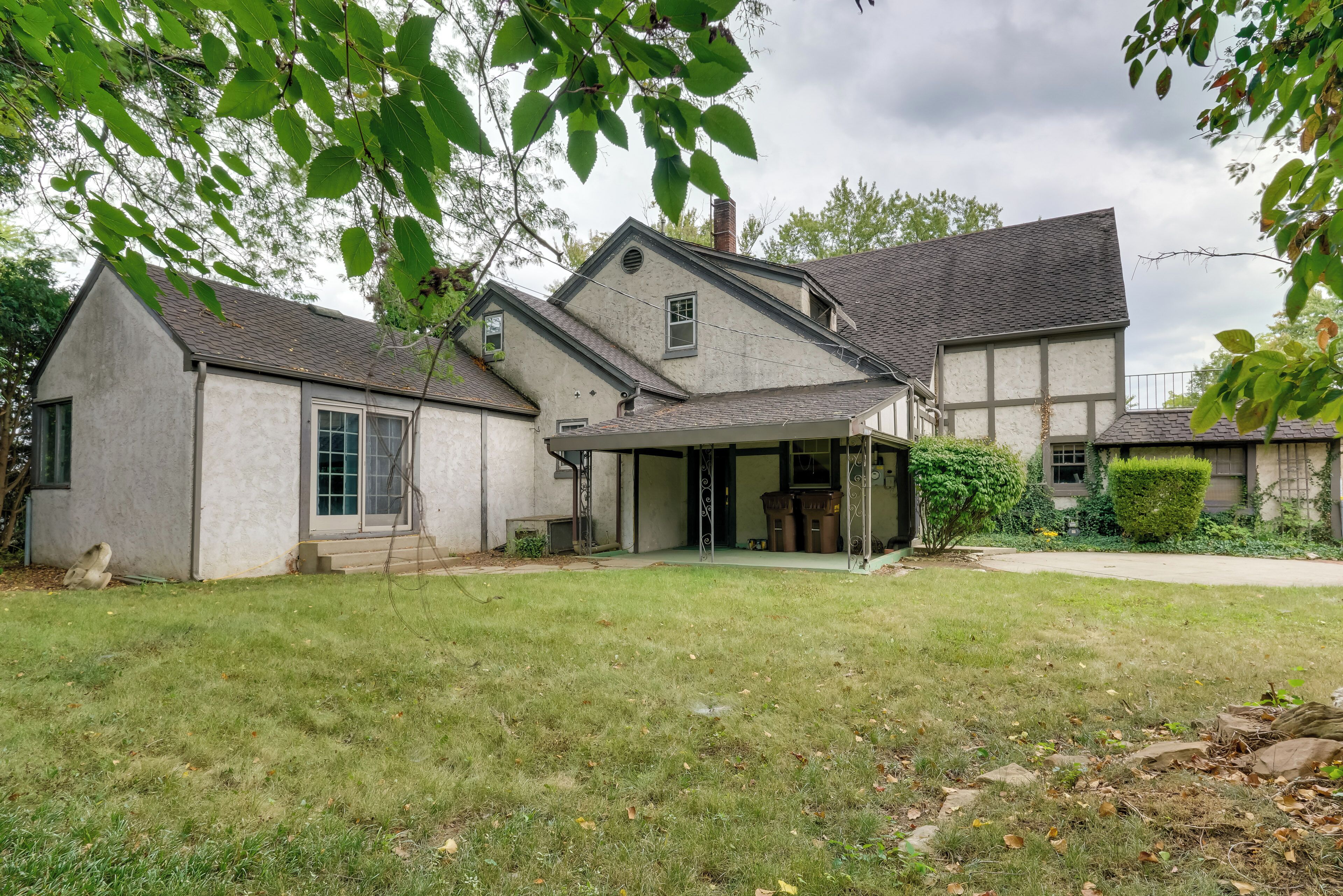 Une maison à deux étages avec un porche abrité et une pelouse bien entretenue.