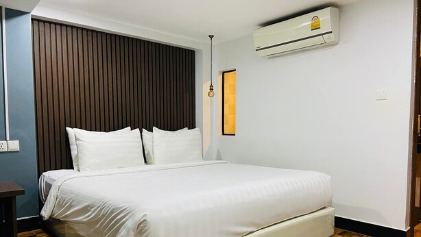 Una camera da letto con un letto grande, pavimento in legno e condizionatore d'aria a parete.