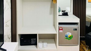Una camera d'albergo moderna con armadio a muro, minibar e specchio.