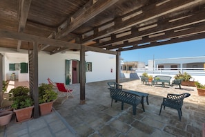 An outdoor patio area with stone flooring, wooden beams, and outdoor furniture. - 3392 Dima Apartments - bilocale 1 by Barbarhouse (Melendugno)