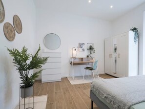 2 habitaciones, escritorio y tabla de planchar con plancha
