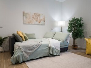A modern living room with a sofa, a floor lamp, a potted plant, and a painting on the wall. - [7 min from airport] Design house with A/C and WiFi (ciampino)