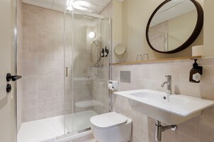 Habitación estándar doble | Baño | Ducha, secador de pelo, toallas y jabón