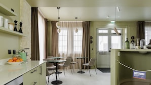 Hotellin ruokailutila, jossa on pitkä pöytä, tuoleja ja buffetpöytä.