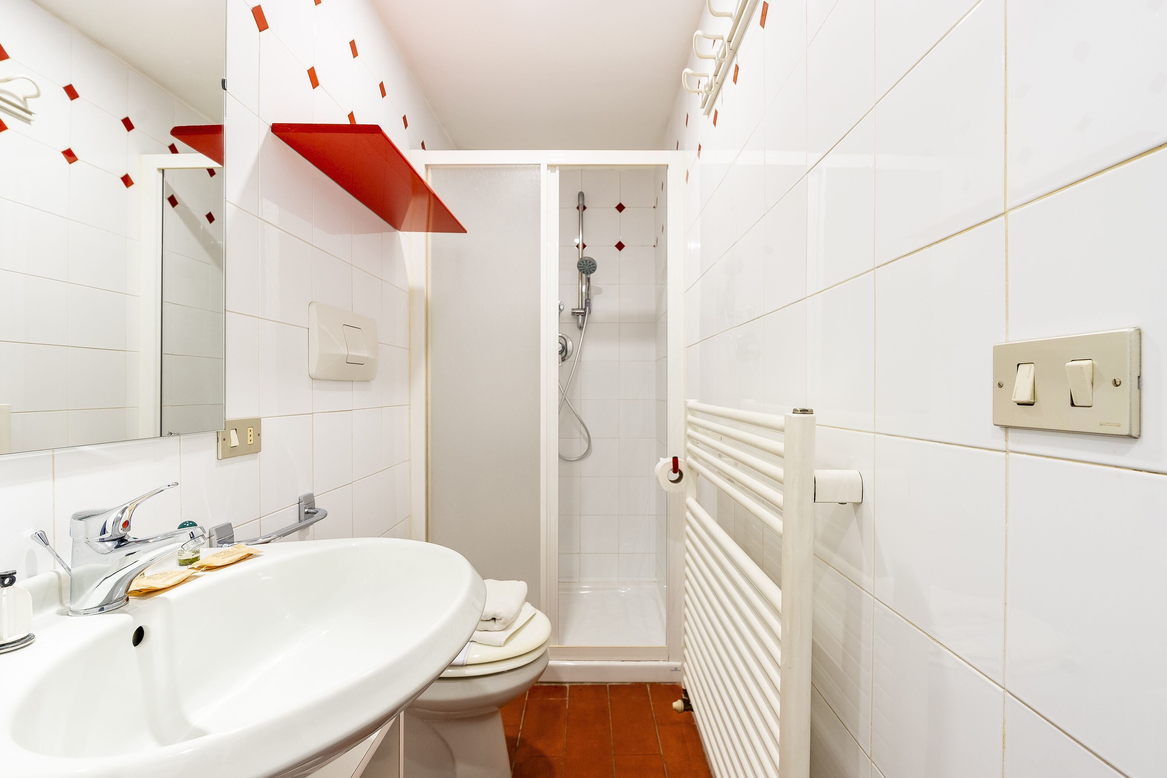 A bathroom with a white sink, toilet, and shower.
