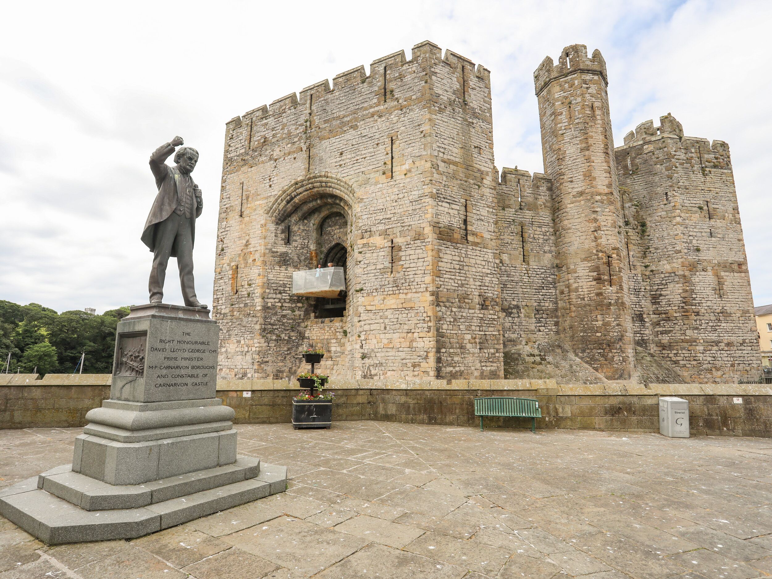A historical stone building with a statue in front.