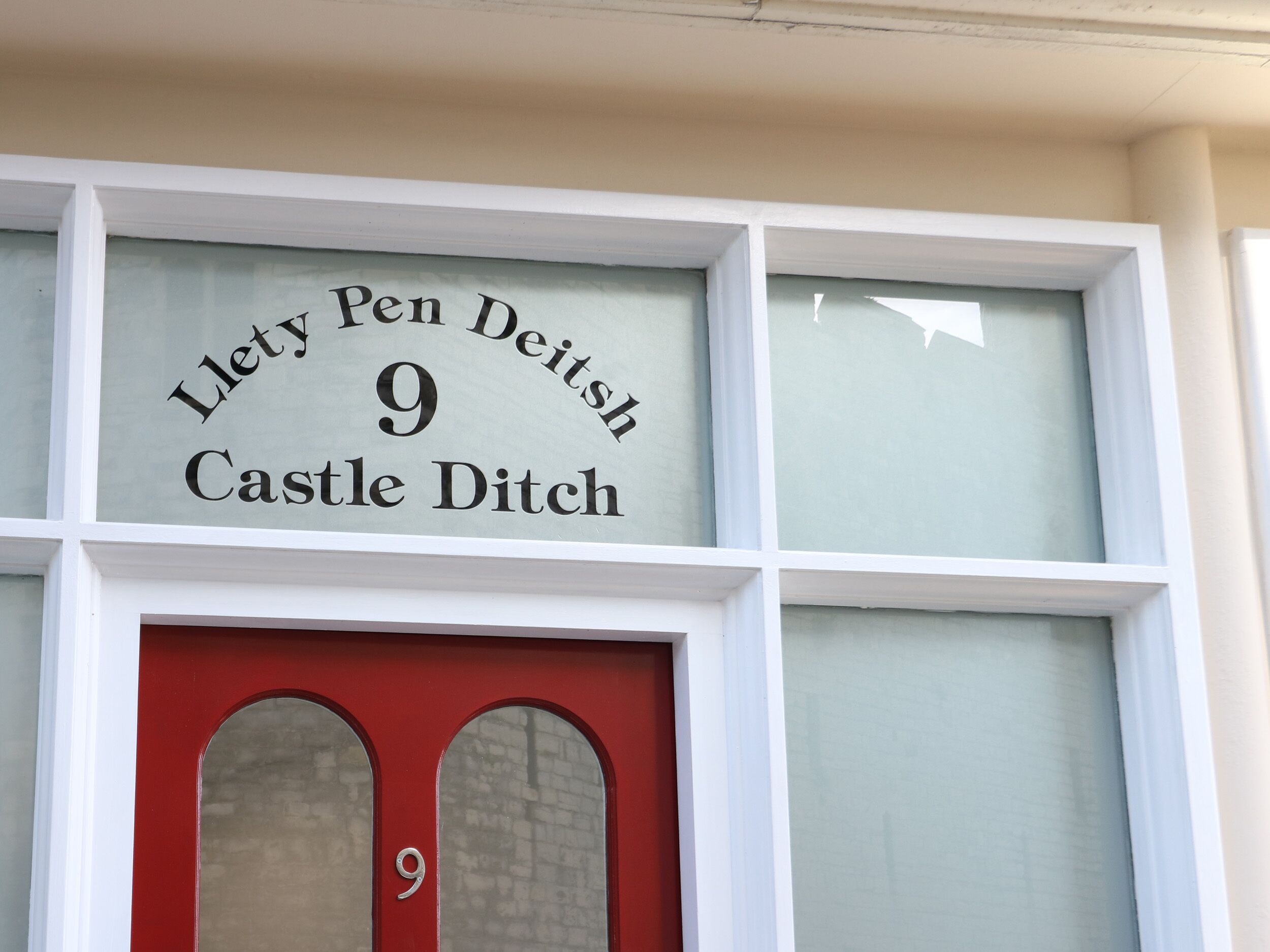 Fachada de edificio con un letrero que dice "Llety Pen Deithsh 9 Castle Ditch".